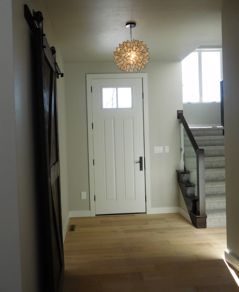 Inspiration for a mid-sized transitional light wood floor and beige floor foyer remodel in New York with beige walls and a white front door