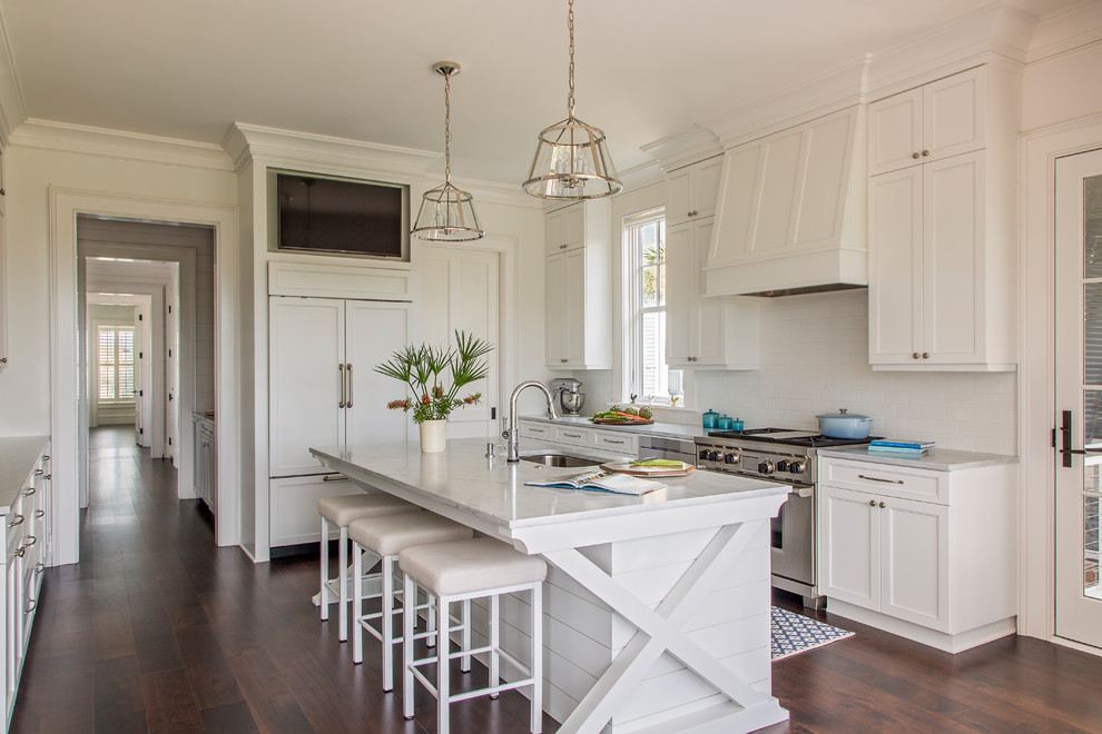 Inspiration for a large beach style kitchen in Charleston with an undermount sink, white cabinets, marble benchtops, white splashback, dark hardwood floors, with island, brown floor, shaker cabinets and panelled appliances.