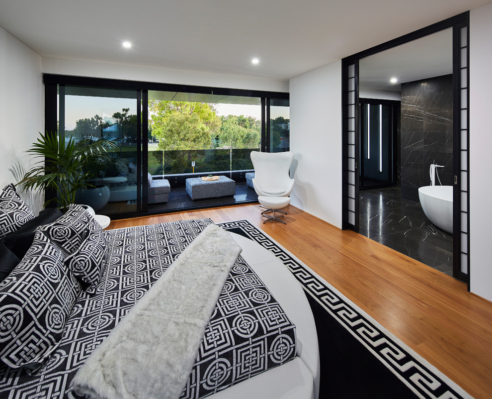 Contemporary master bedroom in Perth with white walls, medium hardwood floors and brown floor.