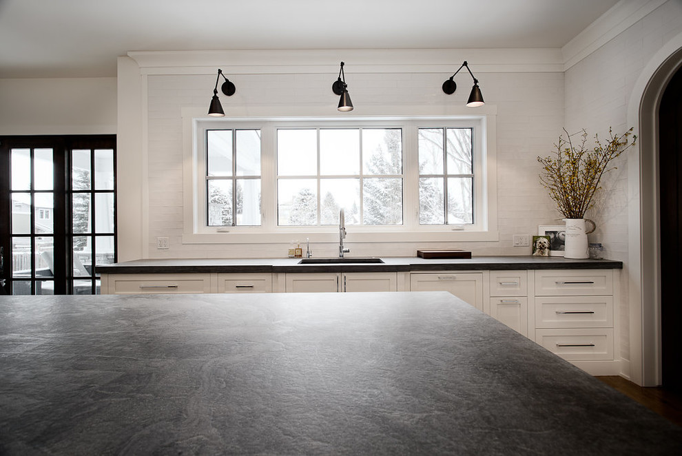Inspiration for a large transitional u-shaped eat-in kitchen remodel in Calgary with shaker cabinets, paneled appliances and an island