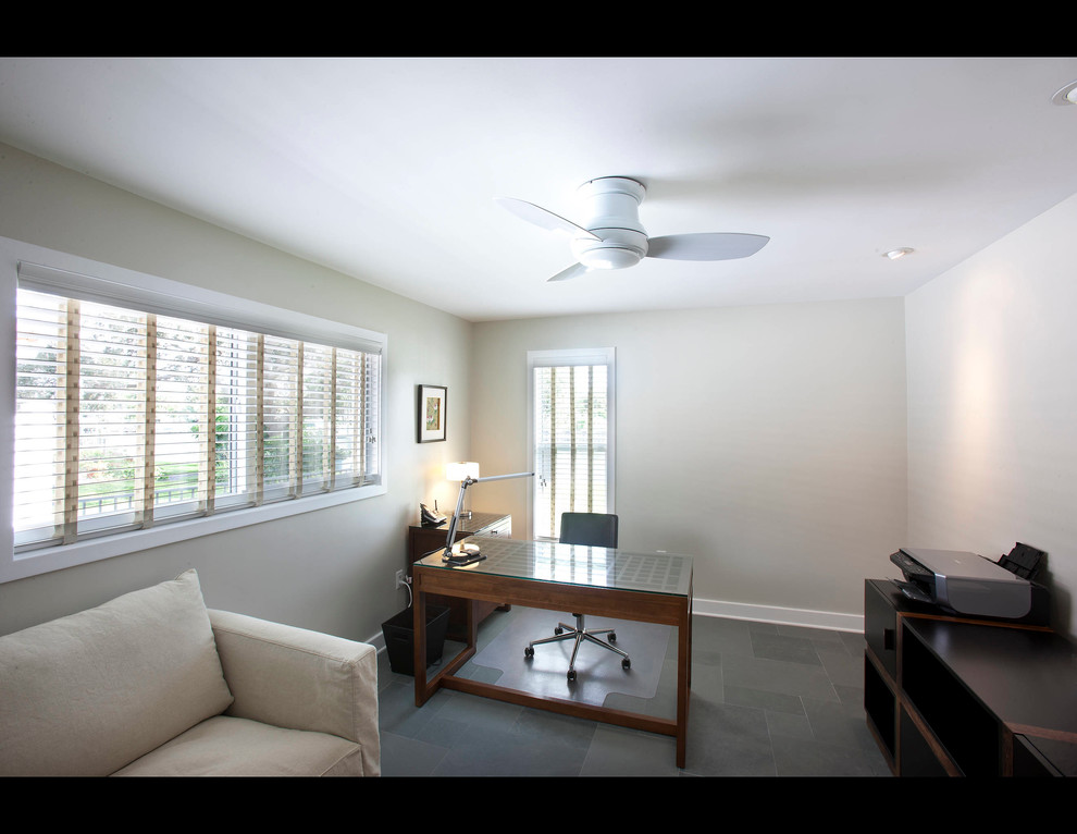 Photo of a mid-sized contemporary study room in Tampa with beige walls, slate floors and a freestanding desk.