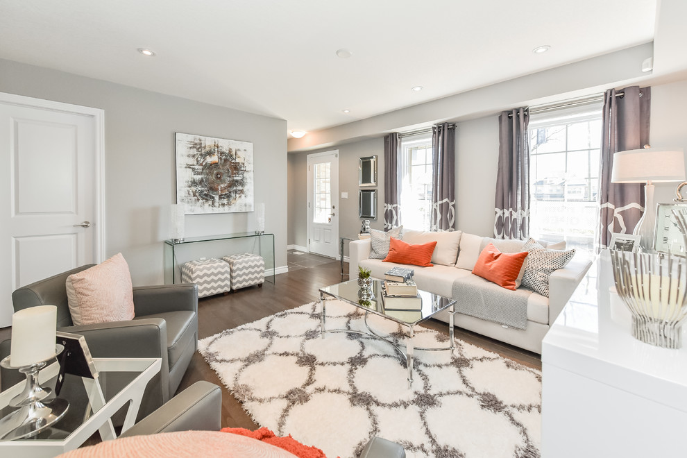 Photo of a mid-sized transitional open concept living room in Toronto with grey walls, medium hardwood floors, no fireplace and a wall-mounted tv.