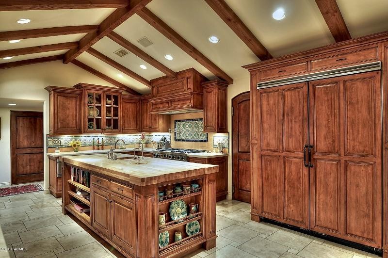 Large transitional u-shaped ceramic tile kitchen photo in Phoenix with a drop-in sink, raised-panel cabinets, medium tone wood cabinets, solid surface countertops, multicolored backsplash, mosaic tile backsplash, stainless steel appliances and an island