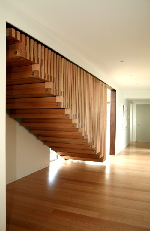 Photo of a mid-sized modern wood floating staircase in Wellington with wood risers.