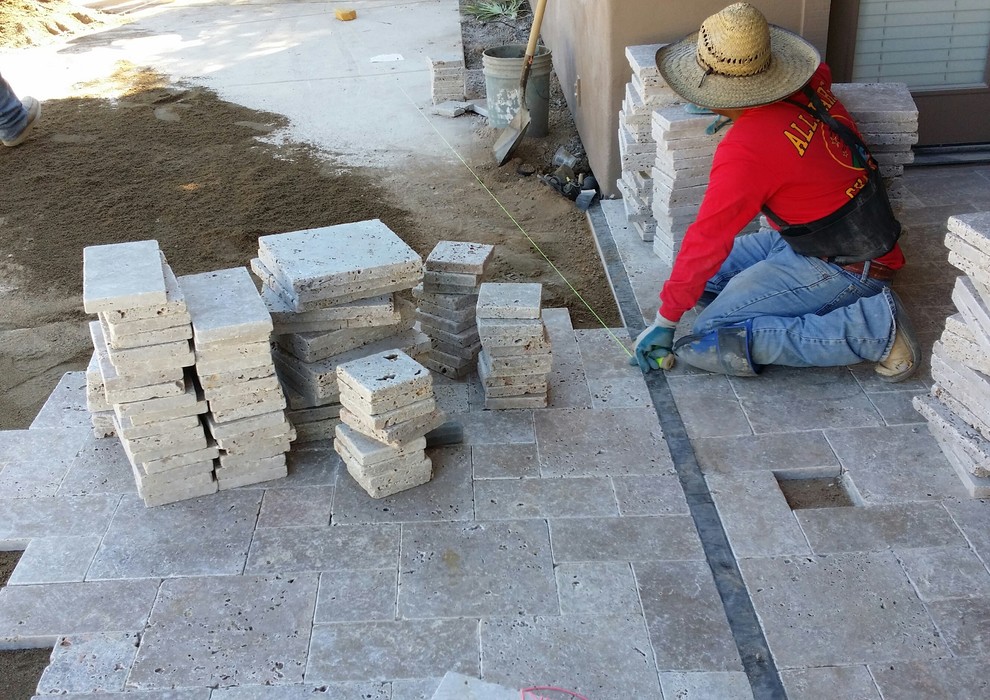 Travertine stone pavers being layed to update the patio