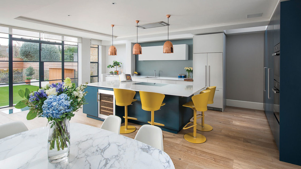 This is an example of a mid-sized contemporary single-wall eat-in kitchen in London with an undermount sink, flat-panel cabinets, with island, blue cabinets, blue splashback, panelled appliances, medium hardwood floors and beige floor.