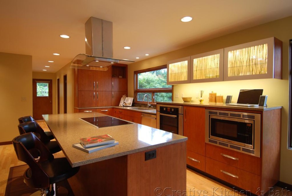 Photo of a mid-sized contemporary l-shaped kitchen in Seattle with an undermount sink, flat-panel cabinets, medium wood cabinets, granite benchtops, light hardwood floors and with island.
