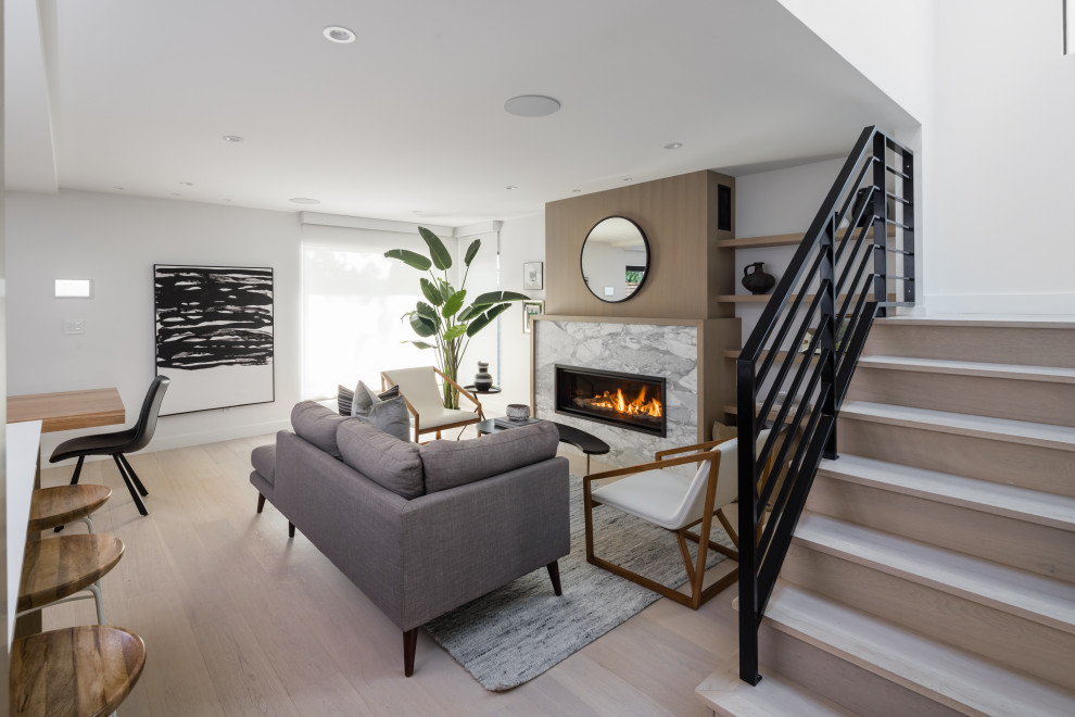This is an example of a mid-sized contemporary formal open concept living room in Vancouver with white walls, light hardwood floors, a ribbon fireplace, a stone fireplace surround, no tv and beige floor.