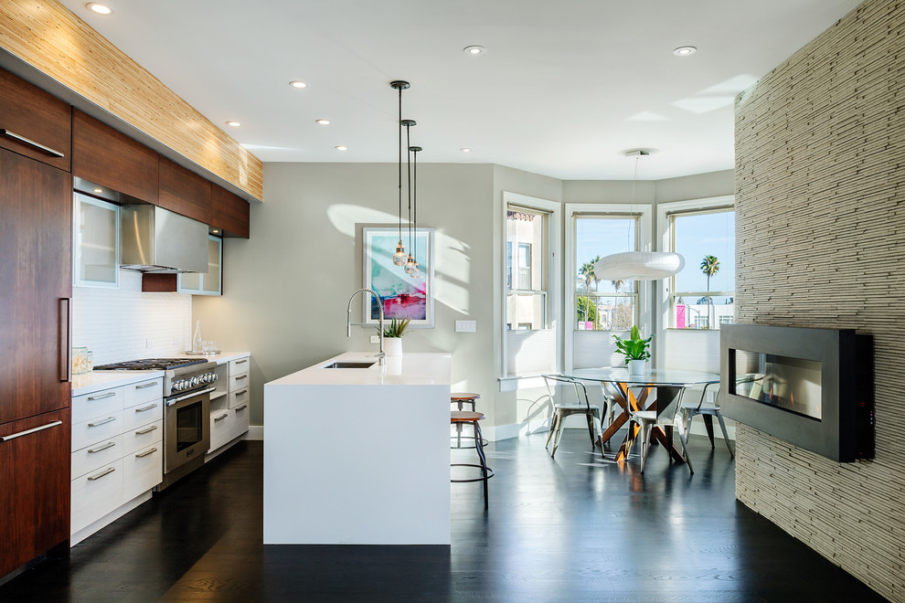 This is an example of a contemporary galley eat-in kitchen in San Francisco with an undermount sink, flat-panel cabinets, white cabinets, white splashback and stainless steel appliances.