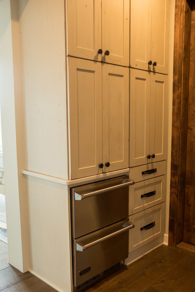 Example of a large transitional galley dark wood floor and brown floor open concept kitchen design with a farmhouse sink, shaker cabinets, quartz countertops, brown backsplash, brick backsplash, stainless steel appliances and an island