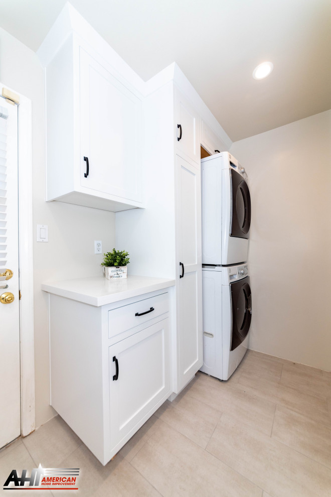 This is an example of a small country l-shaped dedicated laundry room in Los Angeles with shaker cabinets, white cabinets, quartzite benchtops, white walls, ceramic floors, a stacked washer and dryer, beige floor and white benchtop.