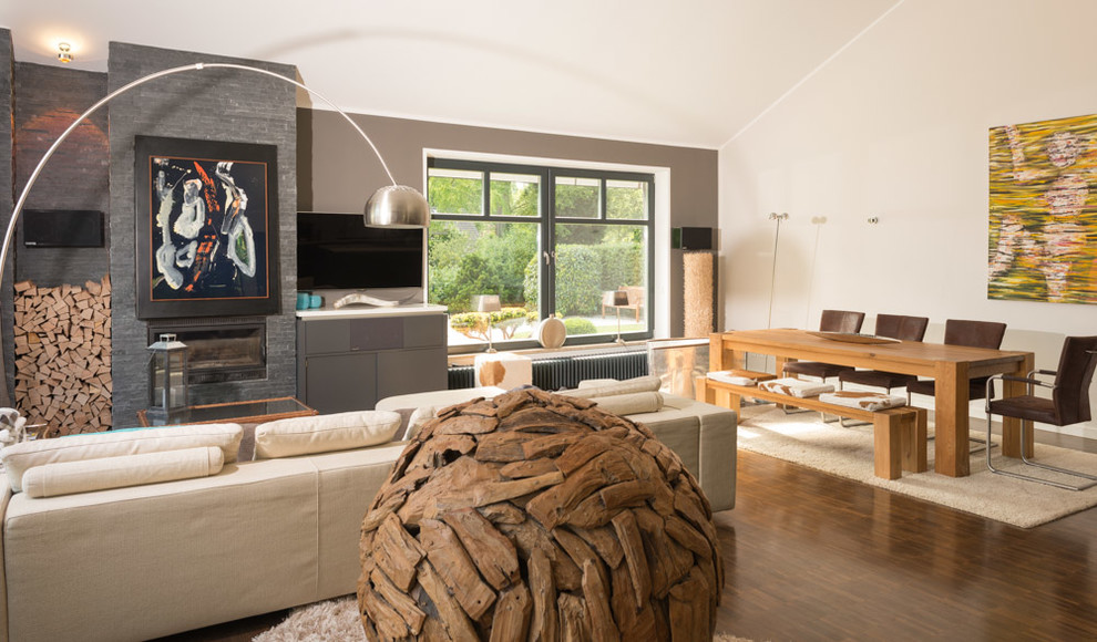 Bibliothek With grauer Wandfarbe, dunklem Holzboden, Kamin, Kaminumrandung aus Stein, braunem Boden and TV-Wand in Hamburg