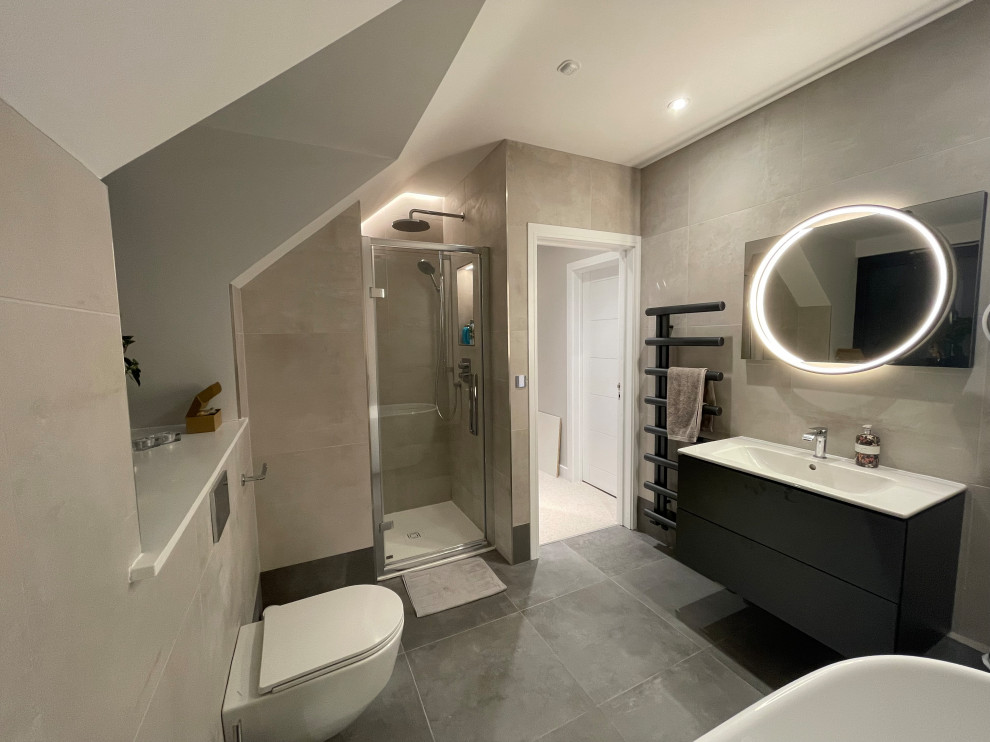 Exempel på ett litet modernt badrum för barn, med släta luckor, grå skåp, ett fristående badkar, en öppen dusch, en vägghängd toalettstol, grå kakel, porslinskakel, vita väggar, klinkergolv i keramik, ett nedsänkt handfat, grått golv och med dusch som är öppen