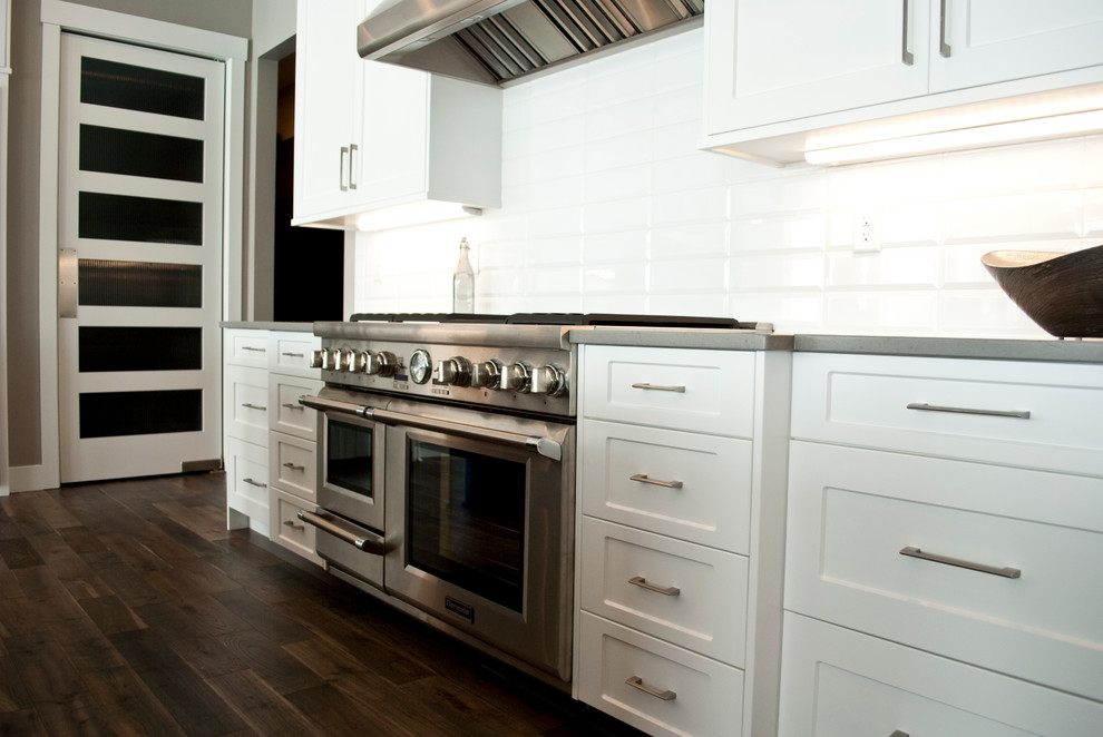 Transitional kitchen photo with recessed-panel cabinets, white cabinets, quartz countertops, white backsplash, stainless steel appliances and an island