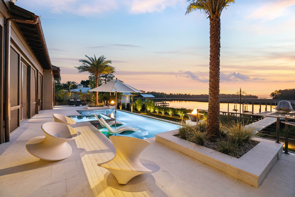 Huge transitional backyard stone and rectangular infinity hot tub photo