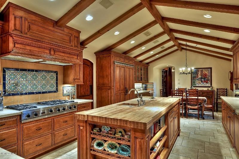 Inspiration for a large transitional u-shaped ceramic tile kitchen remodel in Phoenix with a drop-in sink, raised-panel cabinets, medium tone wood cabinets, solid surface countertops, multicolored backsplash, mosaic tile backsplash, stainless steel appliances and an island