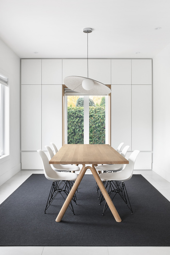 Inspiration for a mid-sized modern dining room in Montreal with white walls, ceramic floors and grey floor.
