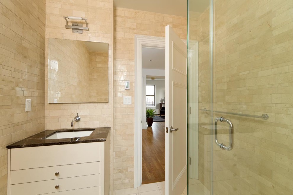 This is an example of a contemporary bathroom in New York with marble benchtops.