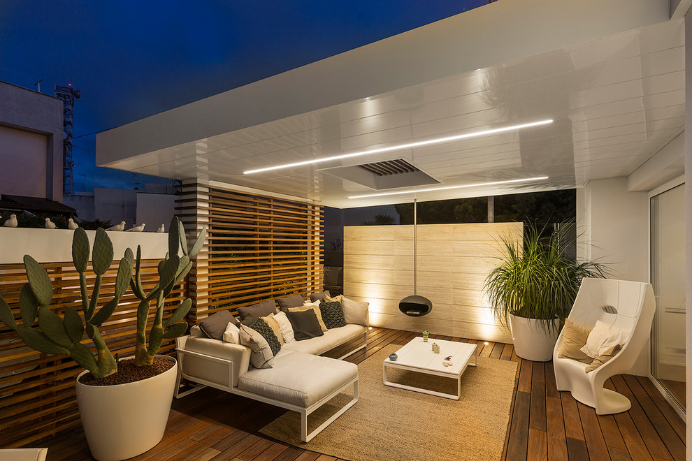 Inspiration for a mid-sized contemporary backyard deck in Bari with a fire feature and a roof extension.