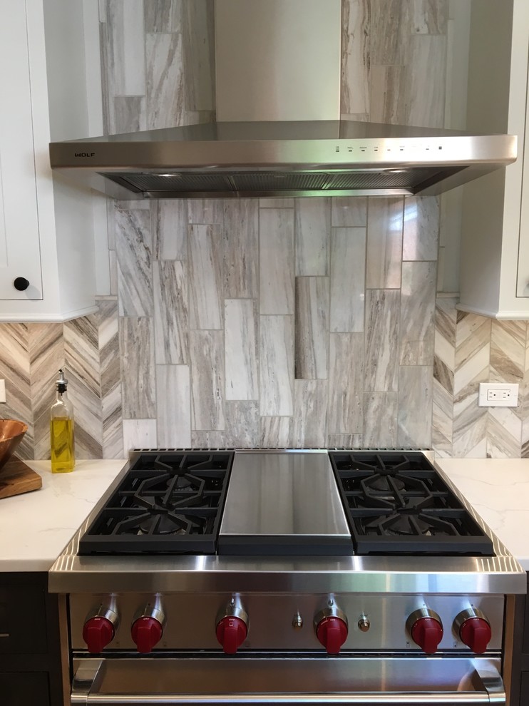 Eat-in kitchen - small transitional galley medium tone wood floor and brown floor eat-in kitchen idea in Chicago with stainless steel appliances, a farmhouse sink, shaker cabinets, gray cabinets, quartzite countertops, gray backsplash, stone tile backsplash, no island and white countertops