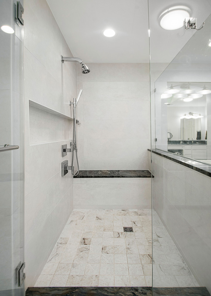 ダラスにある高級な中くらいなモダンスタイルのおしゃれなマスターバスルーム (フラットパネル扉のキャビネット、白いキャビネット、アルコーブ型浴槽、コーナー設置型シャワー、分離型トイレ、白いタイル、ベージュの壁、アンダーカウンター洗面器、珪岩の洗面台、白い床、開き戸のシャワー、グレーの洗面カウンター、洗面台2つ、造り付け洗面台) の写真