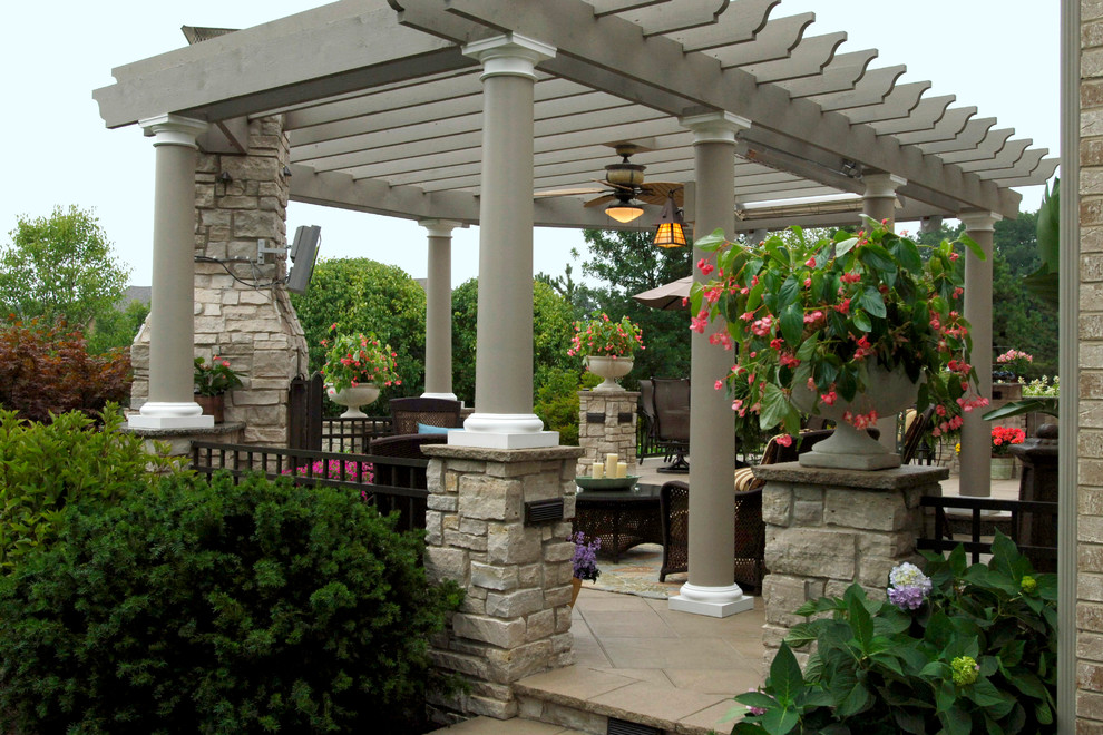 Photo of a large contemporary backyard patio in Chicago with an outdoor kitchen, concrete pavers and a pergola.