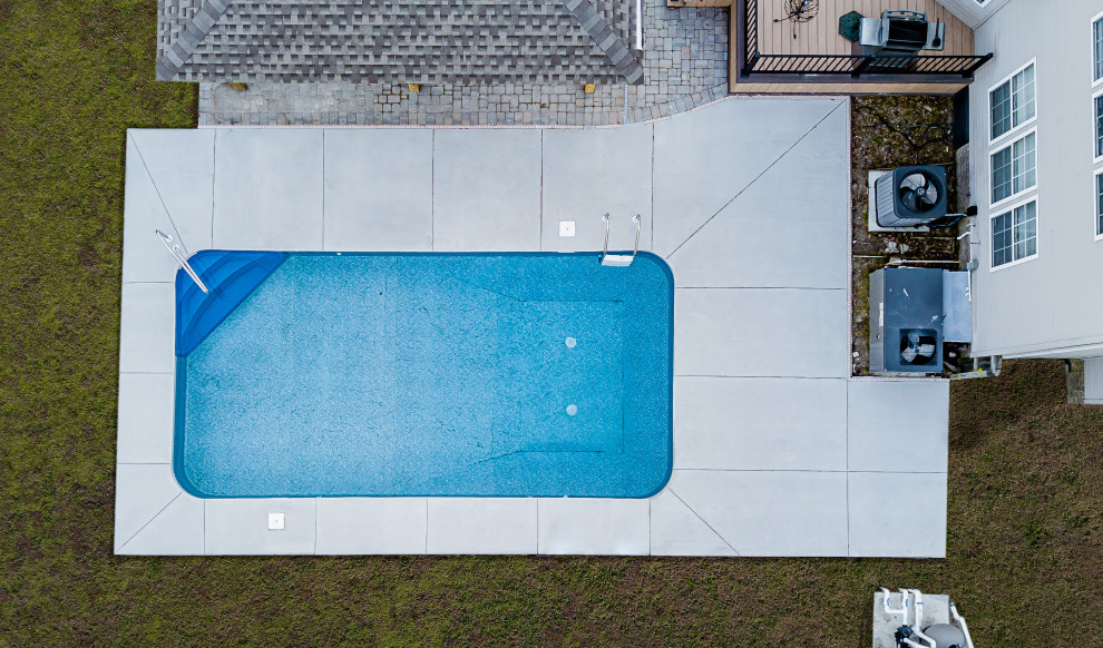 Источник вдохновения для домашнего уюта: большой спортивный, прямоугольный ландшафтный бассейн на заднем дворе в стиле модернизм с покрытием из бетонных плит