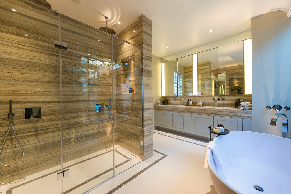 Photo of a large modern master bathroom in London with recessed-panel cabinets, blue cabinets, a freestanding tub, a double shower, a wall-mount toilet, green tile, marble, green walls, porcelain floors, an integrated sink, marble benchtops, white floor, a hinged shower door and green benchtops.