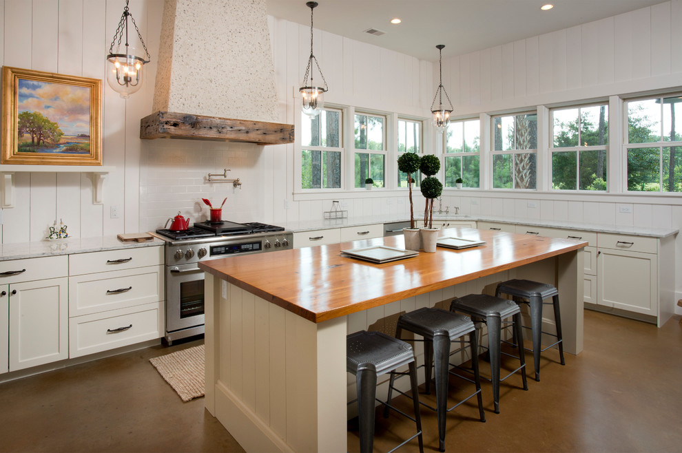 This is an example of a beach style l-shaped kitchen in Atlanta with shaker cabinets, white cabinets, white splashback, stainless steel appliances and with island.