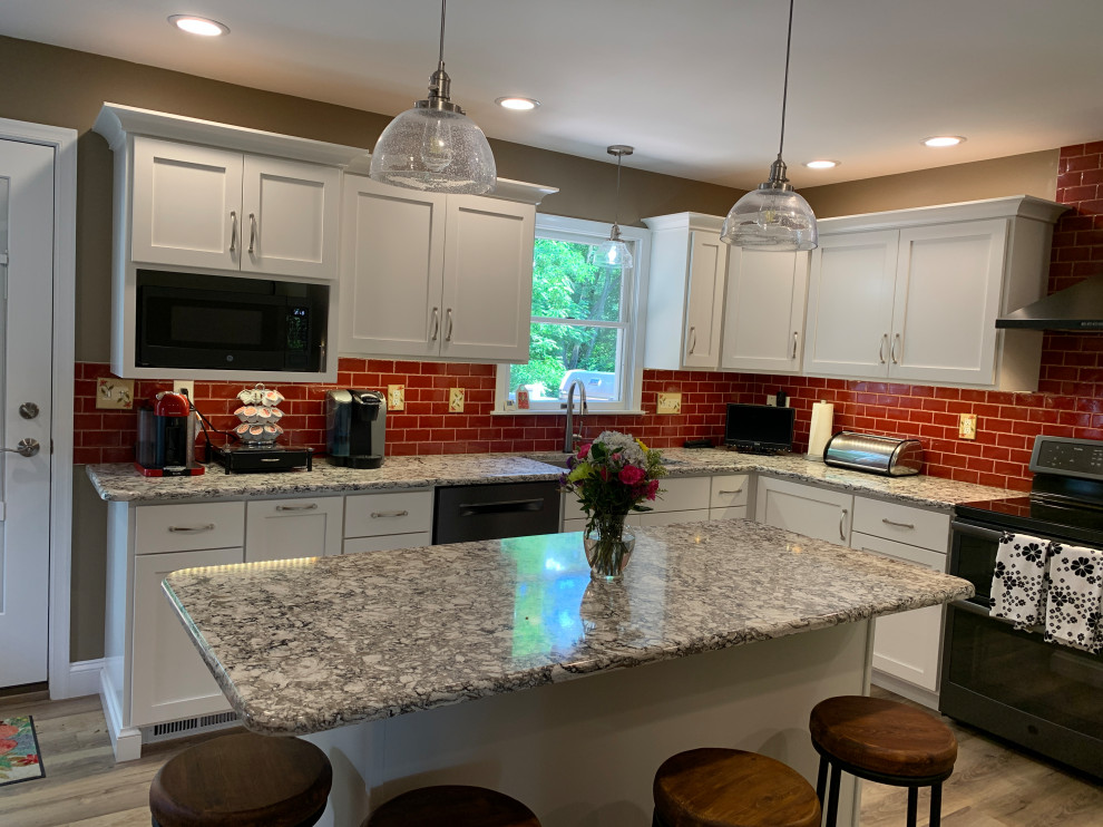 Example of a transitional kitchen design with red backsplash