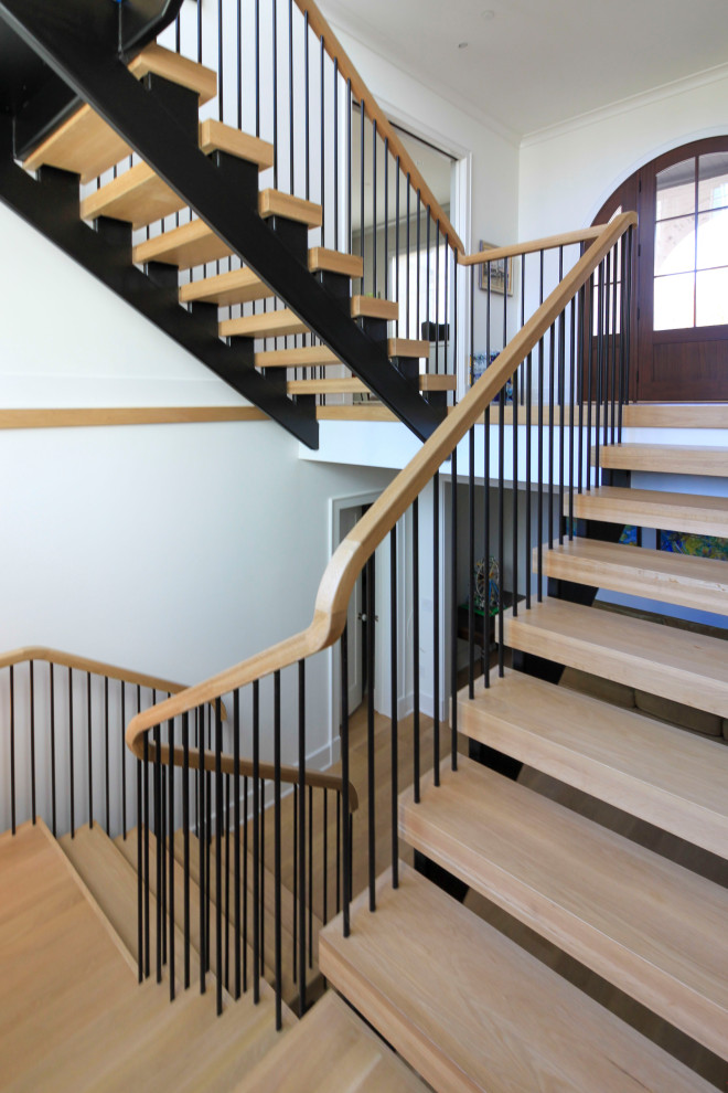 Aménagement d'un très grand escalier flottant moderne avec des marches en bois, un garde-corps en matériaux mixtes et du lambris de bois.