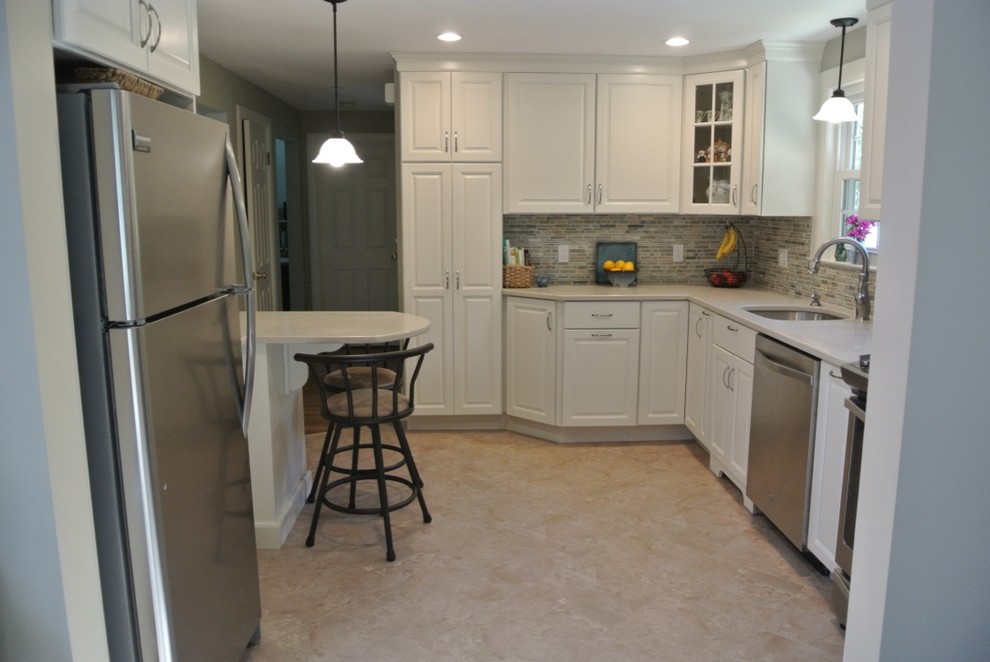 Transitional u-shaped porcelain tile and beige floor kitchen photo in Boston with an undermount sink, raised-panel cabinets, white cabinets, beige backsplash, subway tile backsplash and stainless steel appliances