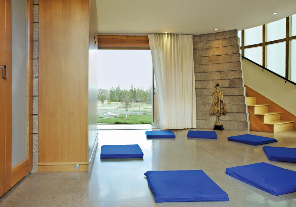 Design ideas for a contemporary home yoga studio in Denver with beige walls and concrete floors.