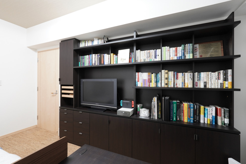 Modelo de despacho minimalista de tamaño medio con paredes blancas, suelo de corcho y escritorio independiente