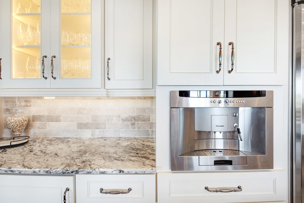Large transitional u-shaped travertine floor and beige floor open concept kitchen photo in Phoenix with a farmhouse sink, recessed-panel cabinets, white cabinets, granite countertops, gray backsplash, porcelain backsplash, stainless steel appliances, an island and multicolored countertops