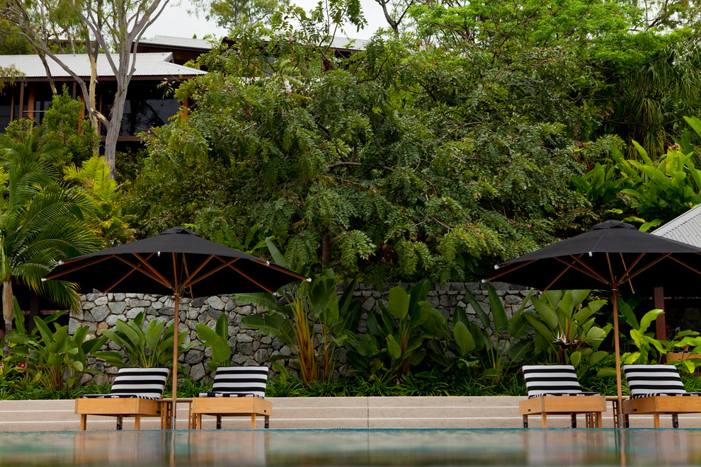Design ideas for a large tropical full sun formal garden in Townsville with concrete pavers.