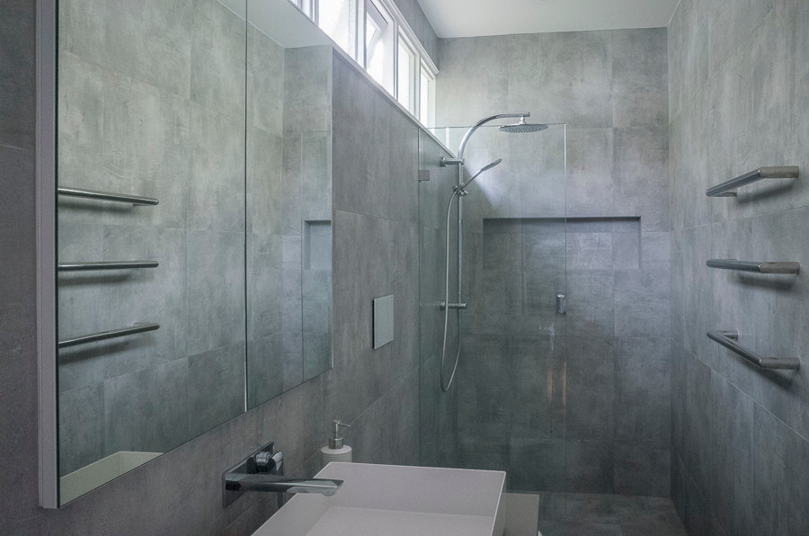 This is an example of a small modern master bathroom in Sydney with furniture-like cabinets, white cabinets, an open shower, a one-piece toilet, gray tile, porcelain tile, grey walls, porcelain floors, a vessel sink, engineered quartz benchtops, grey floor, an open shower and beige benchtops.