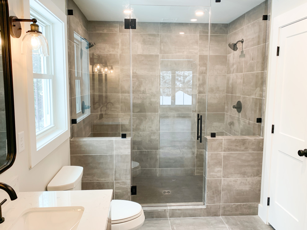 Exempel på ett stort amerikanskt vit vitt en-suite badrum, med möbel-liknande, skåp i mellenmörkt trä, en dubbeldusch, en toalettstol med separat cisternkåpa, grå kakel, keramikplattor, vita väggar, klinkergolv i keramik, grått golv och dusch med gångjärnsdörr