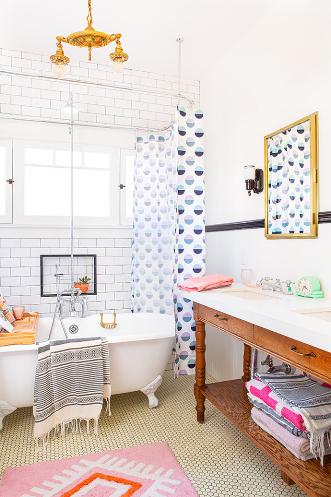 Photo of a mid-sized arts and crafts kids bathroom in Los Angeles with open cabinets, medium wood cabinets, a claw-foot tub, a shower/bathtub combo, a two-piece toilet, white tile, subway tile, white walls, ceramic floors, an undermount sink, engineered quartz benchtops, white floor, a shower curtain and white benchtops.