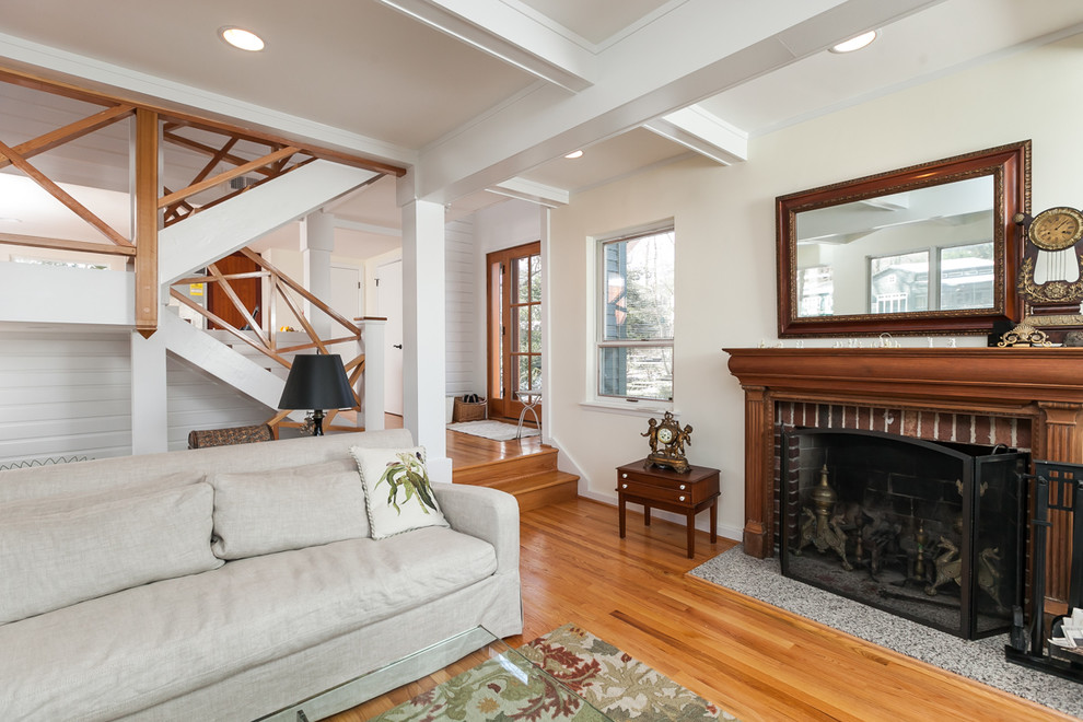 Inspiration for a mid-sized traditional formal open concept living room in DC Metro with yellow walls, medium hardwood floors, a standard fireplace, a brick fireplace surround and no tv.
