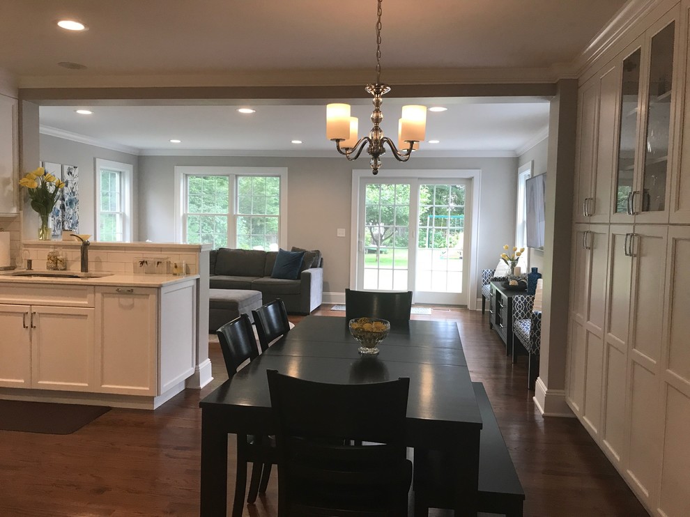 Photo of a mid-sized transitional kitchen/dining combo in New York with grey walls, dark hardwood floors, no fireplace and brown floor.