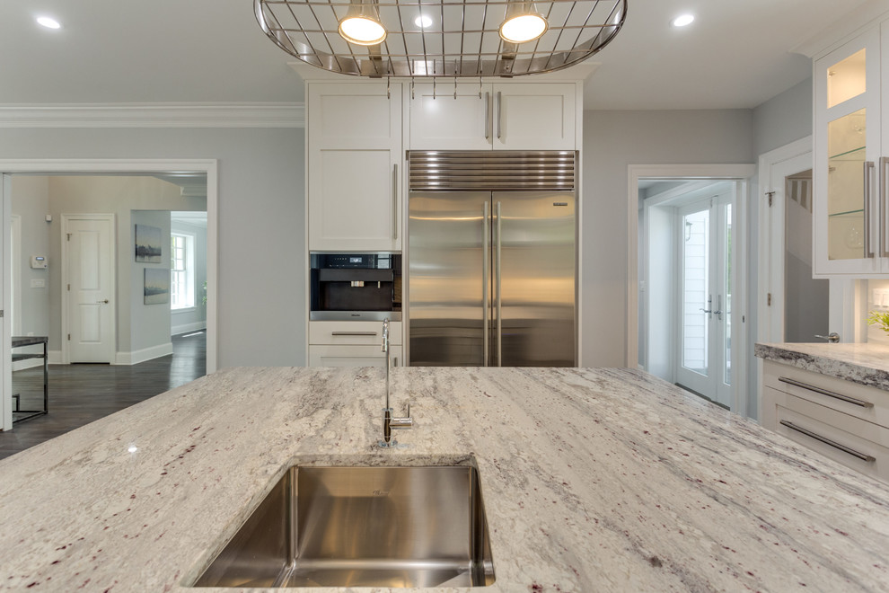 Large transitional l-shaped medium tone wood floor open concept kitchen photo in DC Metro with a single-bowl sink, shaker cabinets, white cabinets, marble countertops, white backsplash, porcelain backsplash, stainless steel appliances and an island