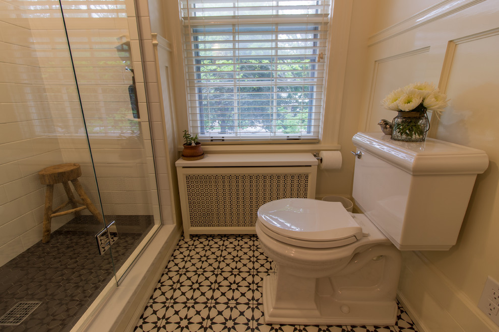 Traditional master bathroom in Minneapolis with an alcove shower, a one-piece toilet, white tile, subway tile, white walls, cement tiles, a console sink and a hinged shower door.