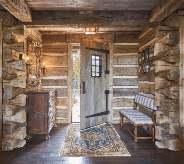 Mid-sized mountain style dark wood floor and brown floor front door photo with beige walls and a light wood front door