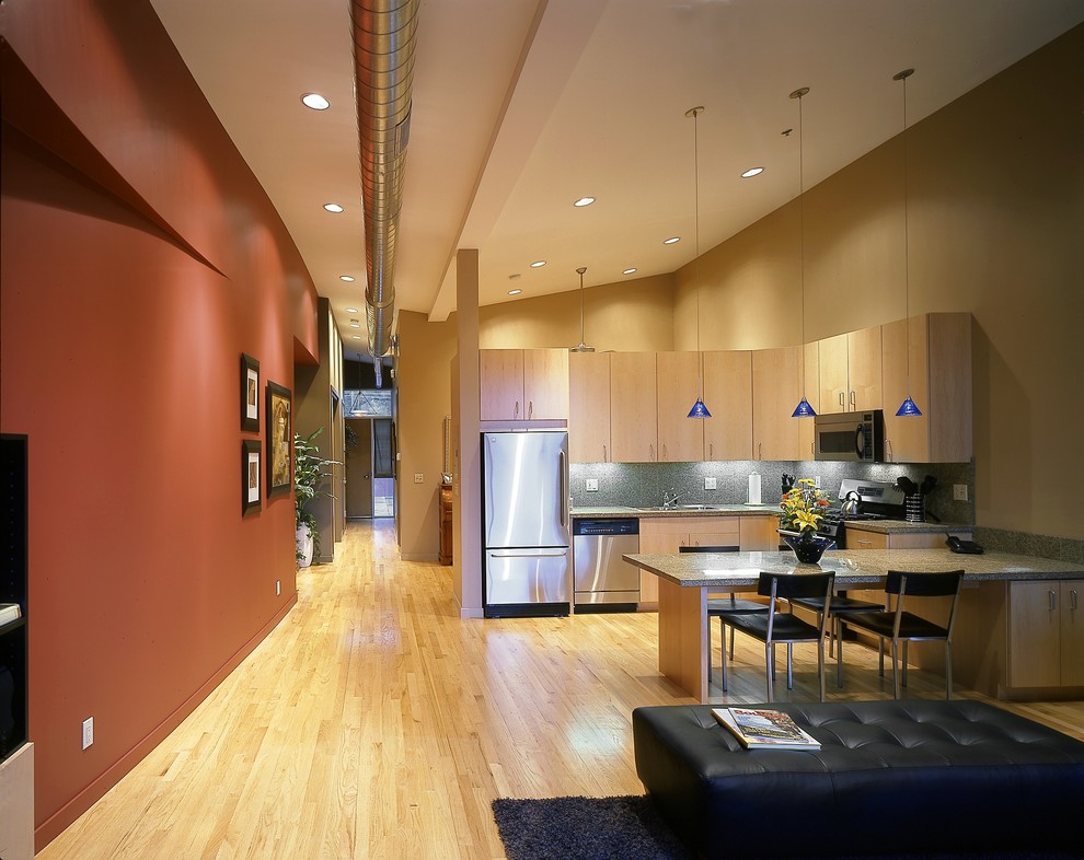 Photo of a contemporary l-shaped eat-in kitchen in Denver with flat-panel cabinets, light wood cabinets and stainless steel appliances.