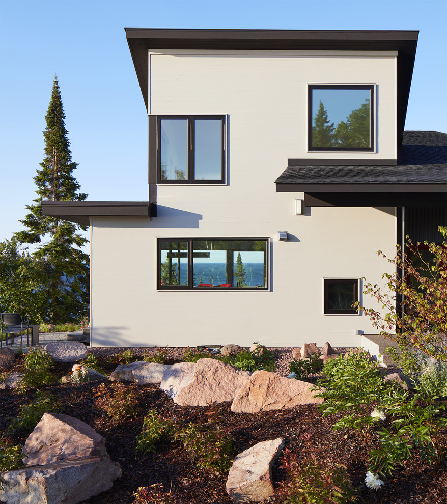 Beach style three-storey house exterior in Minneapolis with metal siding, a shed roof and a shingle roof.