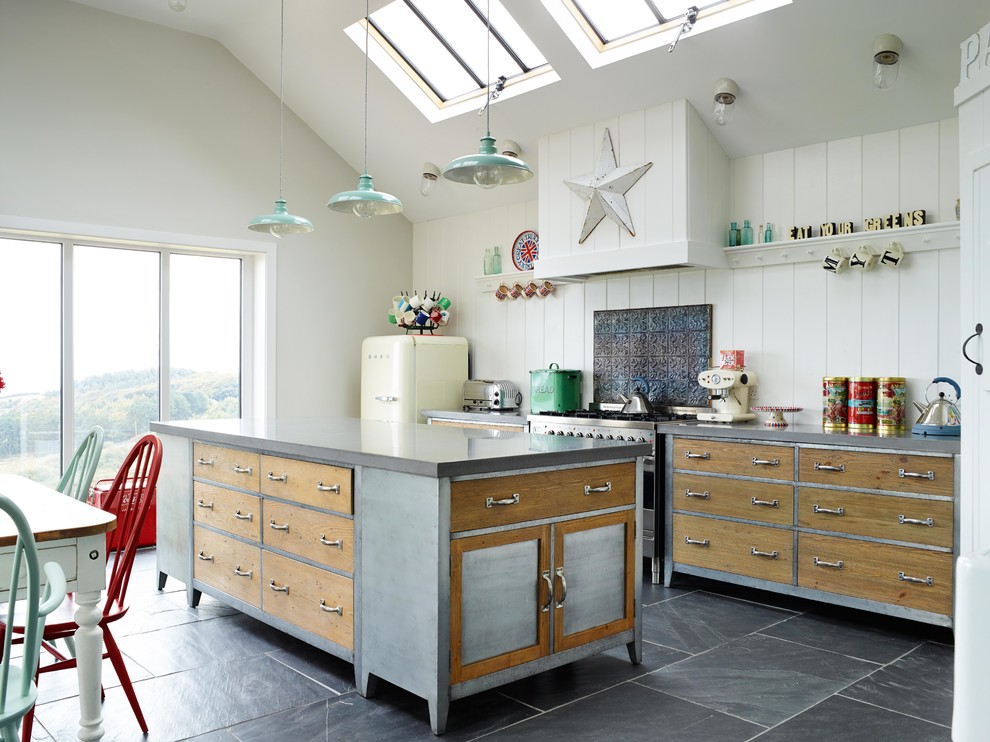 Large eclectic galley open plan kitchen in Kent with distressed cabinets, concrete benchtops, white splashback, with island, open cabinets, timber splashback, stainless steel appliances and grey floor.
