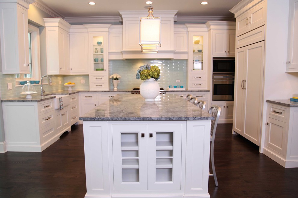 Inspiration for a mid-sized traditional u-shaped eat-in kitchen in Chicago with a farmhouse sink, recessed-panel cabinets, white cabinets, marble benchtops, blue splashback, subway tile splashback, stainless steel appliances, dark hardwood floors and with island.