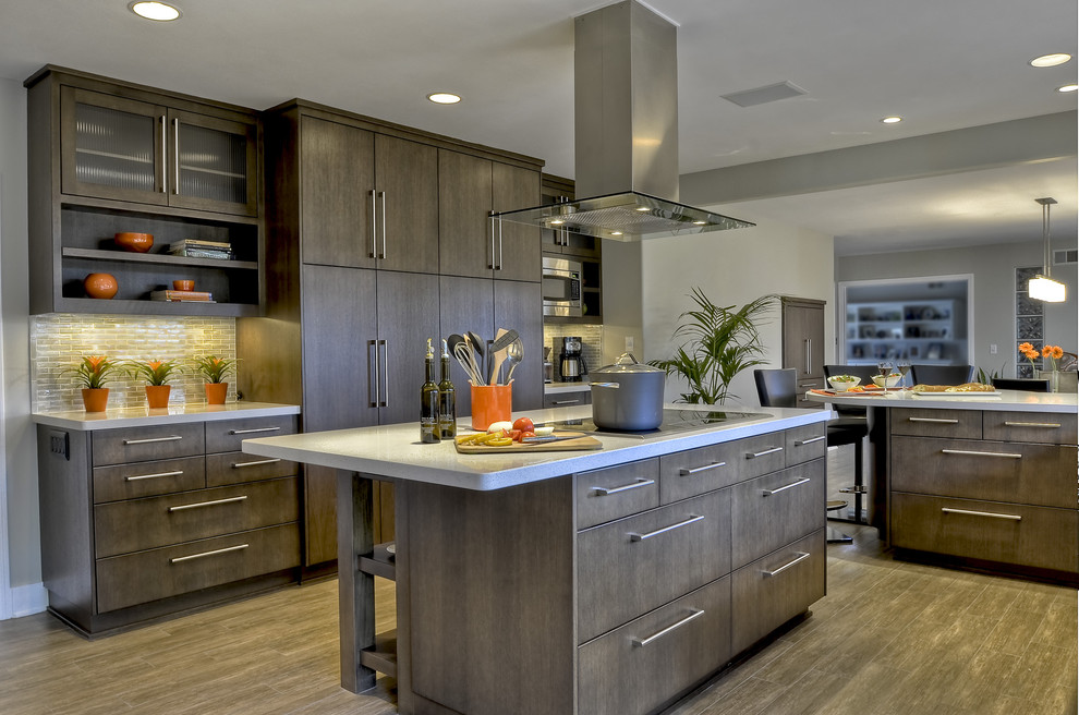 Expansive contemporary u-shaped kitchen in San Diego with flat-panel cabinets, quartz benchtops, glass tile splashback, porcelain floors, with island, panelled appliances and brown cabinets.