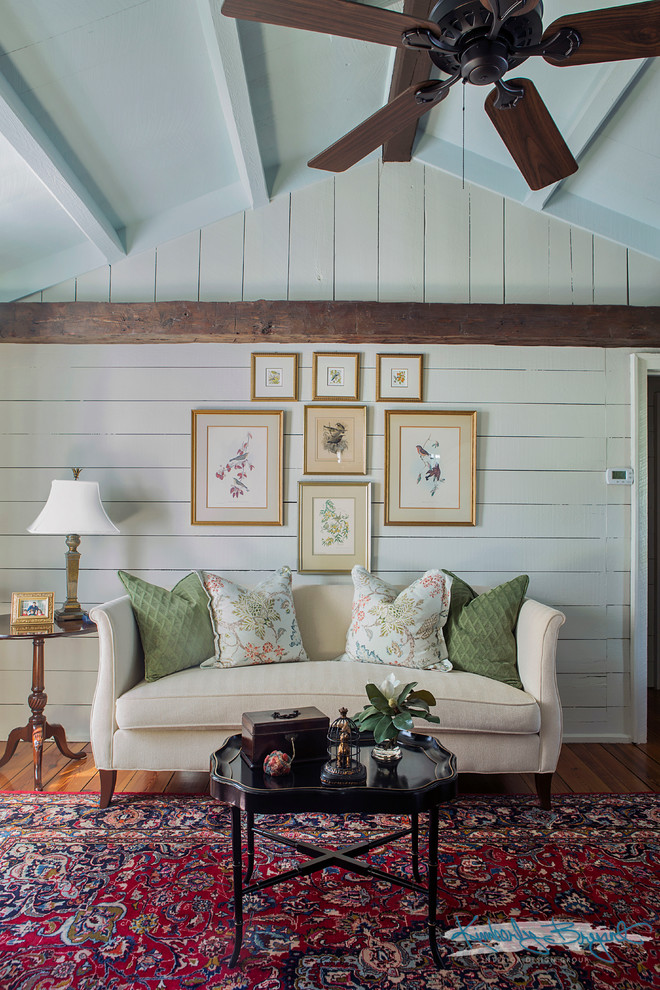 Example of a mid-sized cottage enclosed medium tone wood floor living room design in Charleston with green walls, no fireplace and no tv